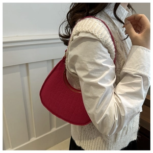 Detail of hot pink crescent shoulder bag featuring crocodile pattern leather texture