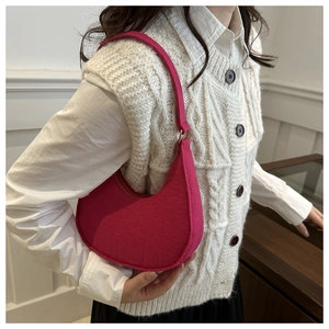 Close-up of bright pink faux crocodile hobo bag worn over shoulder in stylish interior