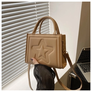 Close-up of beige crossbody bag featuring embossed star design and metallic gold hardware