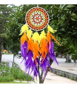 Detail of colorful rainbow dream catcher with vibrant feathers and beads hanging on a tree