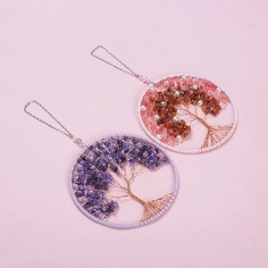 Detailed close-up of handmade Tree of Life dreamcatchers with pink and purple crystals
