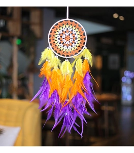Detailed view of handmade dream catcher with vibrant purple and orange gradient feathers