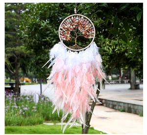 Detail of tree of life dreamcatcher with pink quartz stones and soft feathers