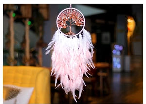 Detail of pink crystal Tree of Life dreamcatcher with soft feathers and copper wire weave