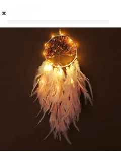 Detail of a lighted tree of life dreamcatcher with pink feathers and LED string lights