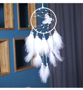 Detalle de plumas blancas suaves y mariposa de encaje en un atrapasueños artesanal