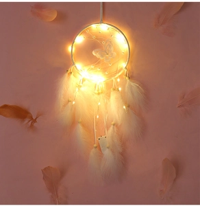 Detalle de atrapasueños de mariposa blanca con luces LED cálidas y plumas suaves