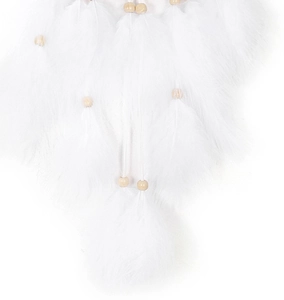 Detalle de un atrapasueños blanco con plumas suaves y cuentas de madera natural de deco