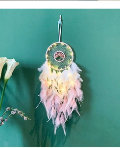 Detail of life tree dream catcher with pink stones, feathers and warm LED lighting