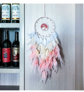 Detailed view of handmade Tree of Life dream catcher with gradient feathers and white beads