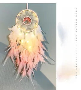 Detail of tree of life dreamcatcher with warm LED lights and pink white feathers