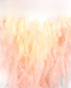 Detail of soft pink and yellow feathers with white beads on tree of life wind chime