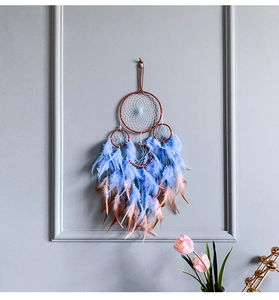 Λεπτομέρεια boho ονειροπαγίδας με μπλε φτερά και σχέδιο φεγγαριού σε γκρι τοίχο