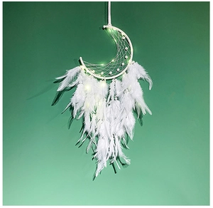Close-up of a white moon-shaped dream catcher with glowing LED lights and soft feathers