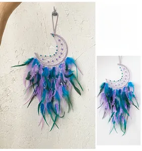 Detail of bohemian crescent moon dreamcatcher with purple feathers and beadwork