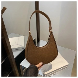 Detail shot of brown crocodile texture on a chic crescent hobo bag for women