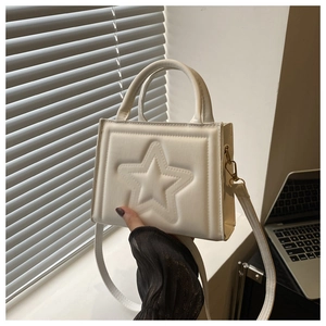 Detail of cream white PU leather handbag featuring a stylish embossed five-point star pattern