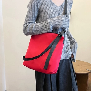Grand sac fourre-tout rouge imperméable en nylon avec bandoulière noire large