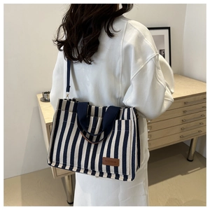 Blue and white striped canvas tote bag with front pocket and detachable shoulder strap