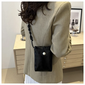 Dettaglio mini borsa nera per telefono con chiusura a perla e tracolla intrecciata