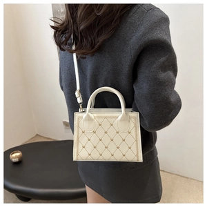 Vue détaillée du sac vintage crème avec broderie coeur matelassée et bandoulière
