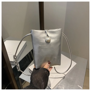 Dettaglio della borsa in pelle argento metallizzato con grande bottone di perla