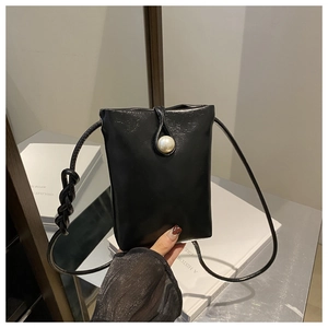 Dettaglio borsa per telefono in pelle nera con grande fibbia di perle e tracolla a corda