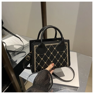Détail des surpiqûres en cœur et finitions dorées du sac bandoulière noir