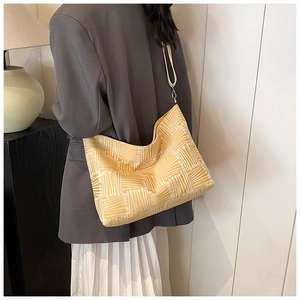 Yellow plaid tote bag styled with a gray suit and white skirt for a modern commute look