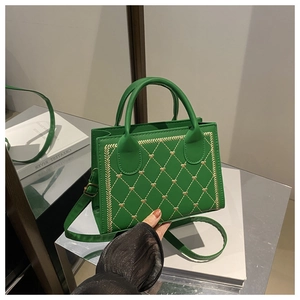 Détail du sac matelassé vert avec broderie cœur dorée et bandoulière réglable