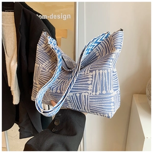 Detail of blue and white knitted texture handbag with wave pattern wide shoulder strap