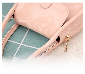 Detailed macro view of pink marble texture handbag with polished gold metal chain strap