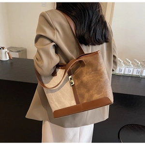 Detail of vintage beige canvas tote bag with brown faux leather trim and gold metal lock