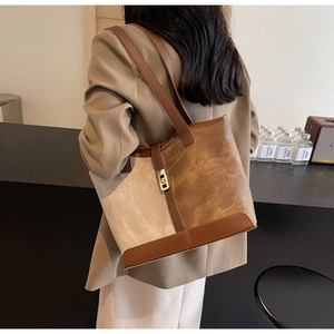 Detail of retro patchwork tote bag with gold metal lock and canvas leather material