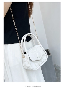 Detail of white marble pattern handbag featuring double handles and a gold chain strap