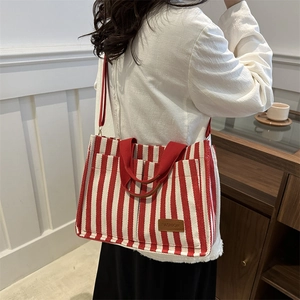 Large red and white striped canvas tote bag with shoulder strap shown from side view