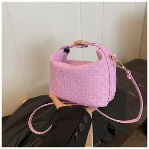 Detail of light purple woven shoulder bag with gold clasp and textured cross-pattern