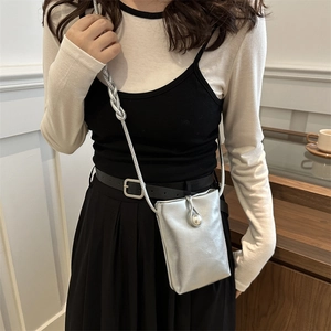 Mini borsa a tracolla argento con fibbia di perla indossata da modella in interno