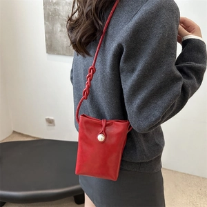 Elegante mini borsa a tracolla rossa con grande fibbia di perle indossata lateralmente