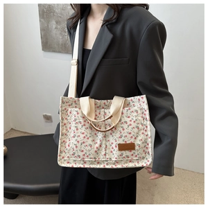 Floral canvas tote bag with adjustable strap and small pink flower patterns close-up view