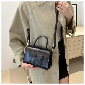 Détail du sac bandoulière noir avec texture plissée et boucle en métal vintage