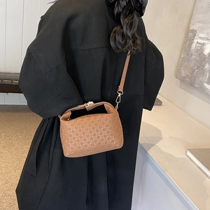 Chic brown woven star pattern crossbody pillow bag shown on a model with black coat