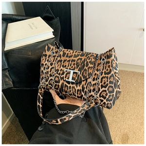 Dettaglio borsa leopardata con fibbia metallica a T e tracolla a catena in argento lucido