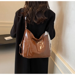 Detail of a brown large-capacity tote bag with number ten and white lace pendant