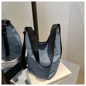 Detail der hellblauen Denim-Einkaufstasche mit breitem schwarzem Lederriemen und viel Platz