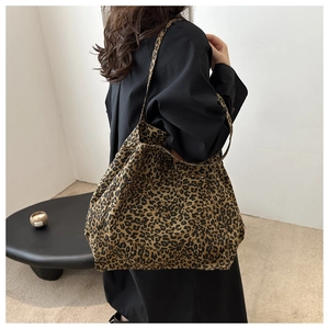 Detailed close-up of leopard print tote bag with soft texture and canvas strap design