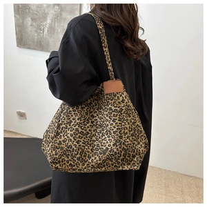Detailed back view of a large leopard print tote bag worn by a model on shoulder