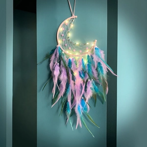 Moon-shaped dream catcher with pink frame, purple feathers, and warm LED lights