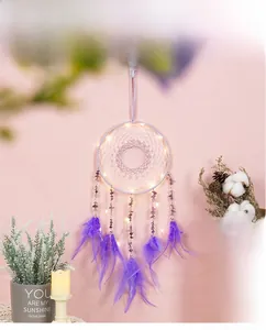 Detail of purple dream catcher with glowing LED lights, soft feathers and crystal stones