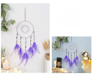 Detail of dream catcher with purple feathers, crystal stones and hand-woven white web